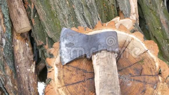 斧子躺在树桩上的树干背景上冬天的柴火视频的预览图