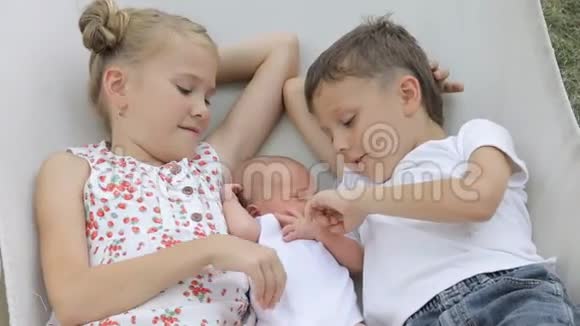 三个快乐的孩子躺在吊床上视频的预览图