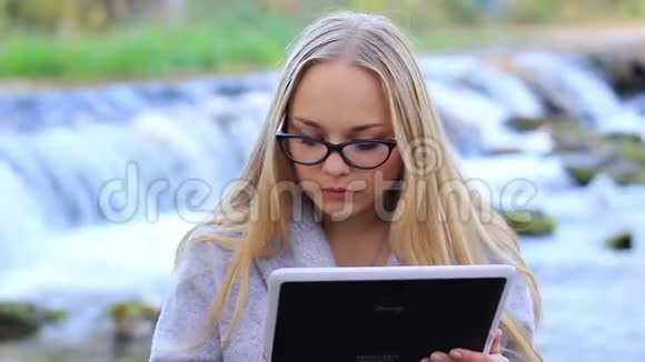 瀑布附近美丽的女孩带着一块石碑视频的预览图