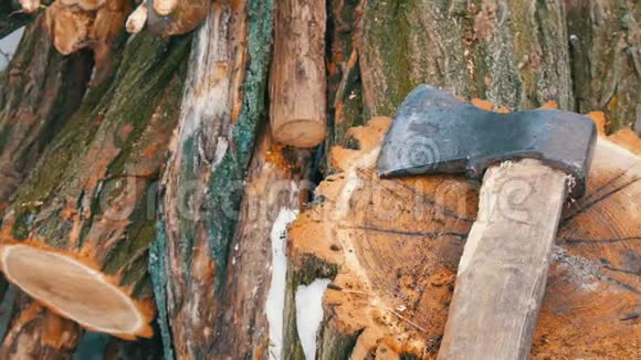 斧子躺在树桩上的树干背景上冬天的柴火视频的预览图