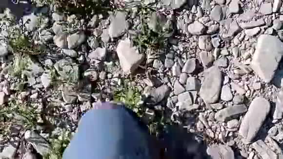 在河旁边的石头上看到了雄性的腿近距离观察男性用石头行走的腿视频的预览图