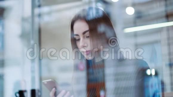 在外面拍摄一个漂亮的女商人一个时尚的样子坐在窗户旁的咖啡馆A在网上冲浪视频的预览图