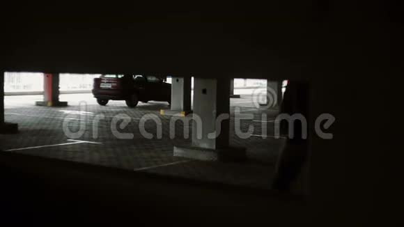 男人穿过黑暗的停车场穿过通道视频的预览图