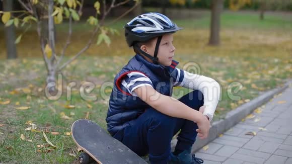 白种人男孩和他的溜冰鞋坐在边境上视频的预览图