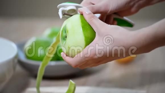 人类的手把绿色的苹果清理成螺旋状视频的预览图
