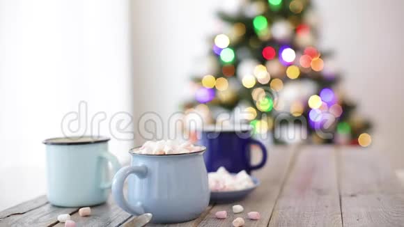 圣诞快乐圣诞树形状的姜饼饼干靠近可可和棉花糖杯美丽模糊的圣诞树视频的预览图
