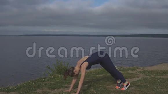 穿蓝色运动服的女人做俯卧撑瑜伽视频的预览图