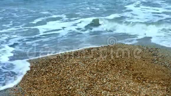 海水的泡沫在夏季海滩的沙质海岸的背景视频的预览图