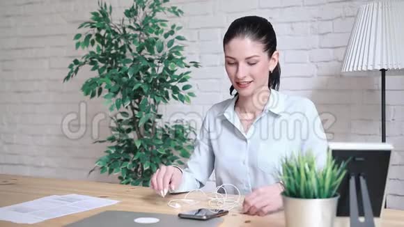 一个女人在办公室的一张桌子上打电话视频的预览图