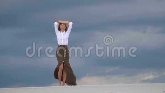 神秘的金发女郎站在沙丘上视频的预览图