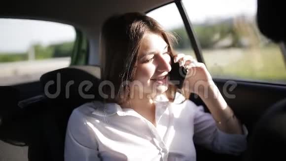 商务女性坐出租车在城市里打电话视频的预览图
