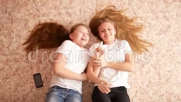 两个十几岁的女孩躺在地板上头发散落在地板上视频的预览图