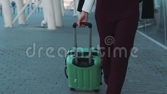 漂亮的年轻女人拉着她的行李打电话在机场积极的生活方式视频的预览图