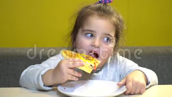 小女孩肖像有趣的在咖啡馆吃披萨片视频的预览图