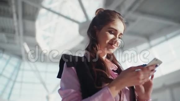 美丽的微笑的女人穿着粉红色衬衫的漂亮化妆在购物中心女孩的注意力集中在视频的预览图