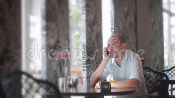 一个在咖啡馆的人在桌上打电话视频的预览图