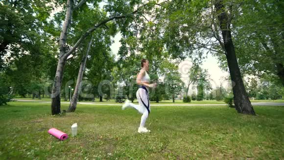 体育女青年正在训练在公园做运动健身女孩在公园做午餐在夏天阳光健身中心视频的预览图