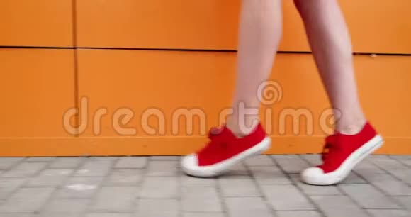 女孩踮起脚尖走路作为街头锻炼注意她穿红色运动鞋的脚视频的预览图