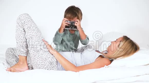 4岁的小家伙和妈妈躺在床上他拍了照视频的预览图