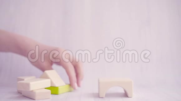 靠近女人的手用五颜六色的木块建立或建造一个玩具屋强烈的家庭观念商务视频的预览图