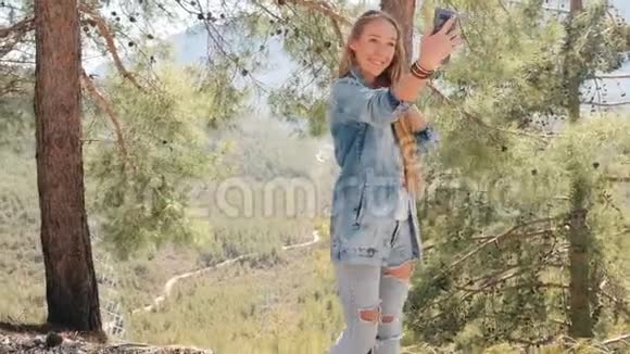 年轻女子在户外用手机自拍视频的预览图
