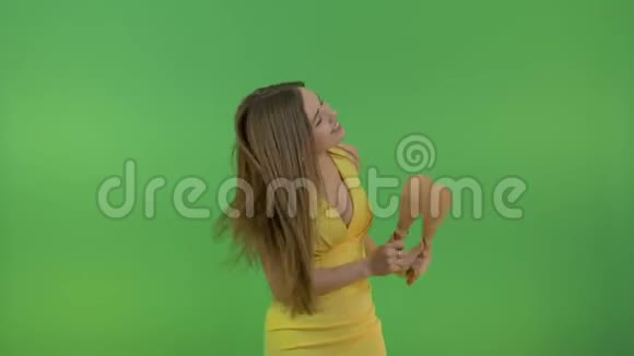 年轻美丽的女孩长发与马拉卡斯跳舞有趣和快乐在绿色的背景上视频的预览图