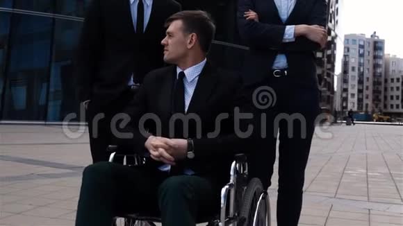 与他的同事坐在轮椅上的残疾男性的史诗般的镜头视频的预览图