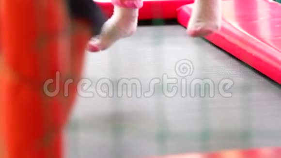 儿童双脚在蹦床上的特写镜头慢镜头视频的预览图