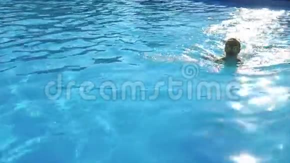 夏天一个戴太阳镜和泳衣的成年女孩在游泳池里游泳视频的预览图