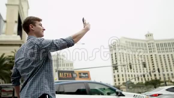 年轻的帅哥在拉斯维加斯的一条街上拍了一张自己的照片视频的预览图
