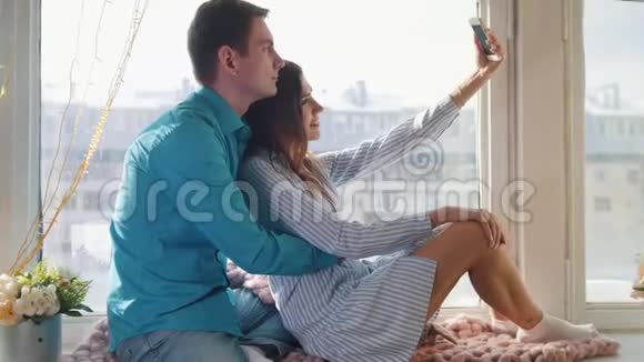 幸福快乐的情侣在窗户上自拍年轻迷人的男女视频的预览图