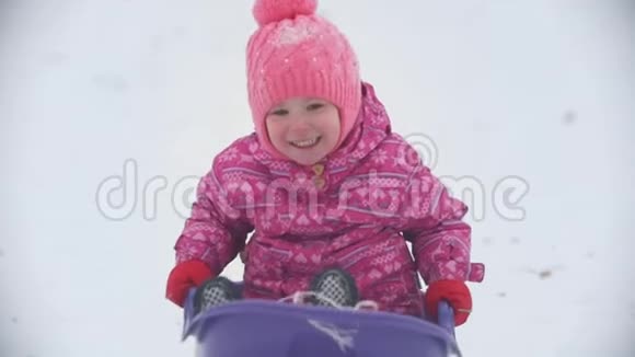 在冬天的公园里滑着雪的小女孩视频的预览图