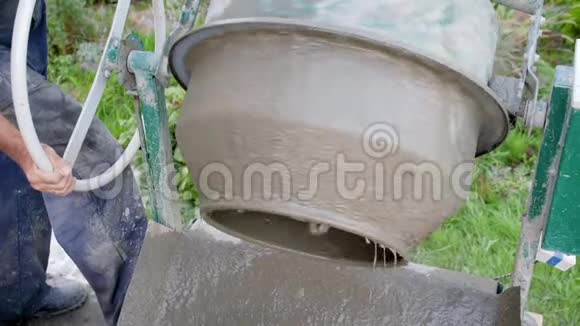 混凝土浇筑施工员搅拌砂浆从水泥搅拌机浇筑混凝土拌合物施工过程视频的预览图