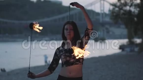 格蕾丝可爱自信的女人表演一个表演与火焰站在森林或公园熟练的火技艺术家展示视频的预览图
