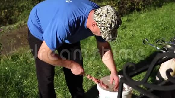 一位老人在美丽的庭院里点燃烧烤炉视频的预览图