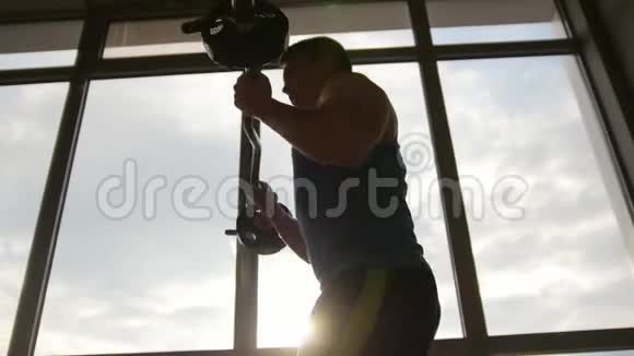 健身肌肉男用杠铃训练二头肌剪影视频的预览图