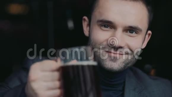 一位穿着正式服装的英俊男子的男性肖像他举起一个啤酒杯敬酒高兴地喝着网络酒肖像视频的预览图
