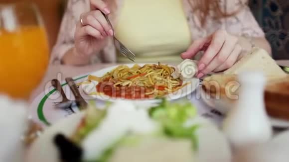 坐在桌旁吃意大利面的女人视频的预览图