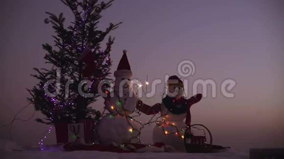 圣诞装饰雪人用冷杉枝和彩灯装饰视频的预览图