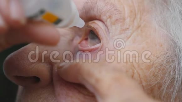 老妇人眼睛里滴着医疗滴祖母的肖像保健和医疗理念快关门视频的预览图