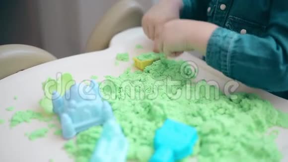 这孩子用双手从绿色动力的沙城堡和塔楼上搭起来视频的预览图