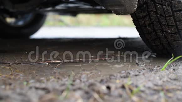 在雨中骑在泥泞的道路上结果是一辆泥泞的汽车泥皮车轮视频的预览图