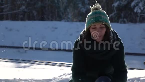 慢镜头美丽的年轻女孩在森林里玩雪球视频的预览图