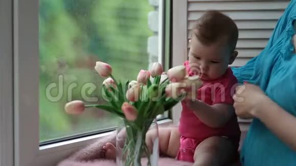可爱的女婴在玩郁金香花视频的预览图
