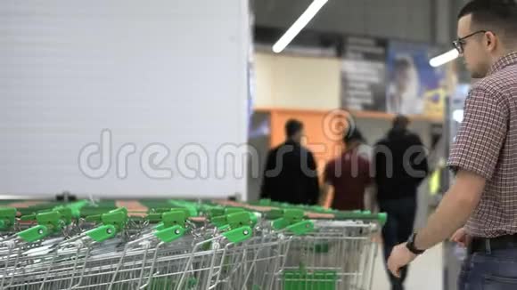 一个年轻人在超市里坐购物车购物和人的概念库存录像视频的预览图