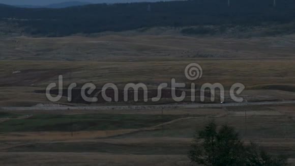 在黑山的田野和群山之间汽车骑行视频的预览图