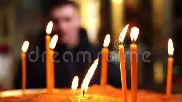 在前景中燃烧蜡烛人在焦点之外视频的预览图