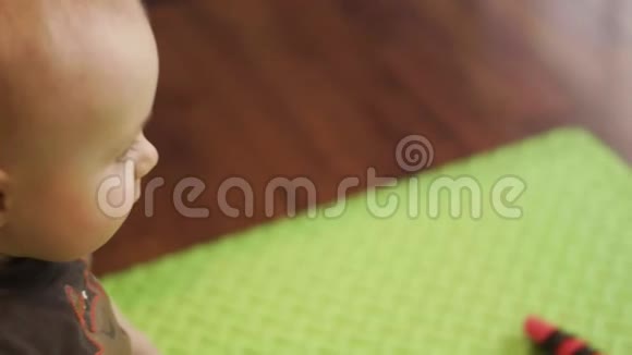 坐在地板上的小婴儿在智能手机上与他的白种人父亲通过视频通话室内4K侧视频的预览图