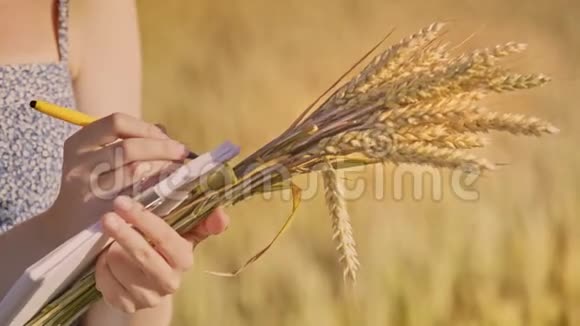 女性手握麦秆书写笔记农业商业研究视频的预览图