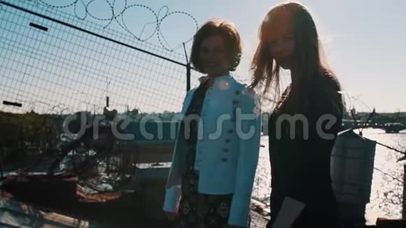 两个可爱的小女孩在屋顶与风景优美的城市河景视频的预览图